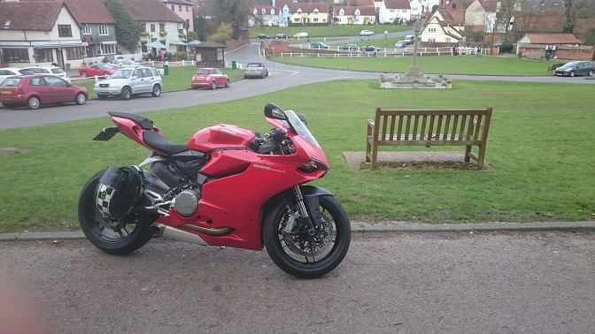 A red motorcycle parked on the side of a road - Pistonheads