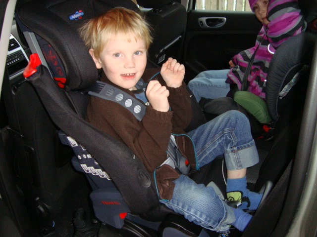 A young boy sitting in a car with a cell phone - Pistonheads