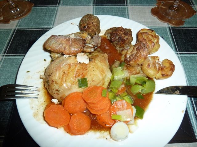 A white plate topped with meat and vegetables