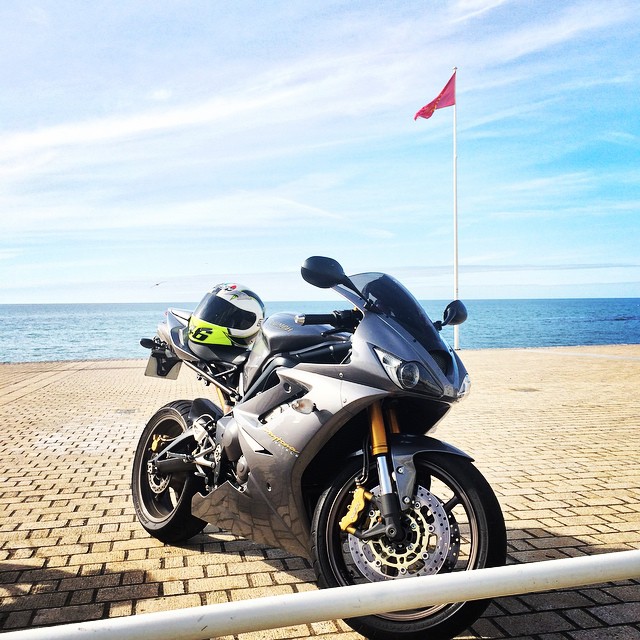 A motorcycle parked on the beach near the ocean - Pistonheads