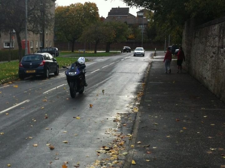A man riding a motorcycle down a street - Pistonheads