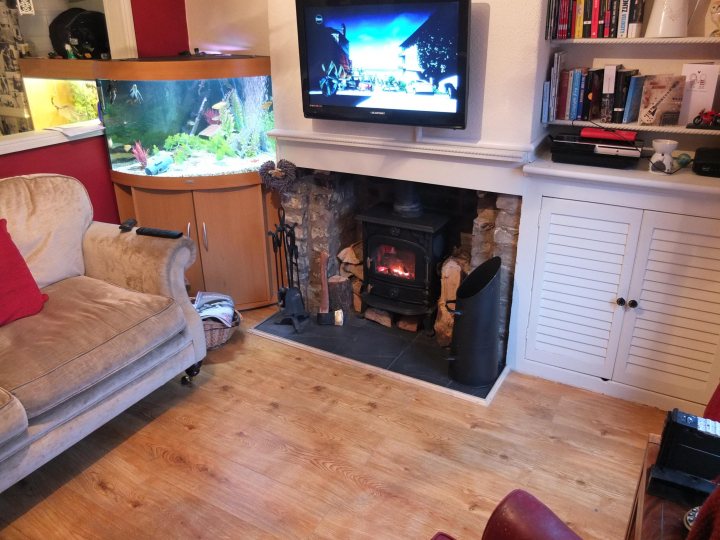 A living room with a fireplace and a tv - Pistonheads