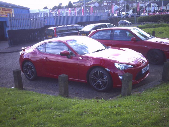 A red car parked in a parking lot - Pistonheads