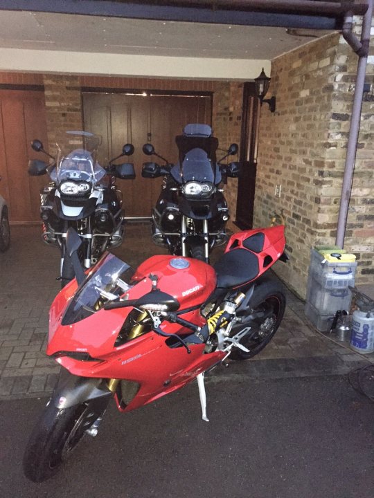 A motorcycle is parked in a garage with other motorcycles - Pistonheads