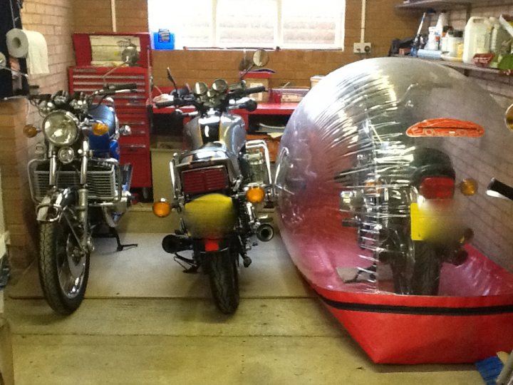 A red motorcycle parked in a garage with other motorcycles - Pistonheads