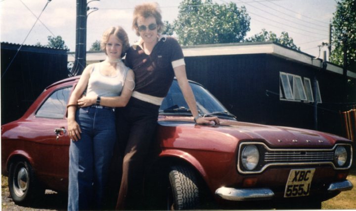A woman standing next to a red car - Pistonheads