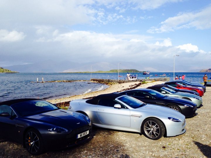 A car parked on the beach next to the ocean - Pistonheads