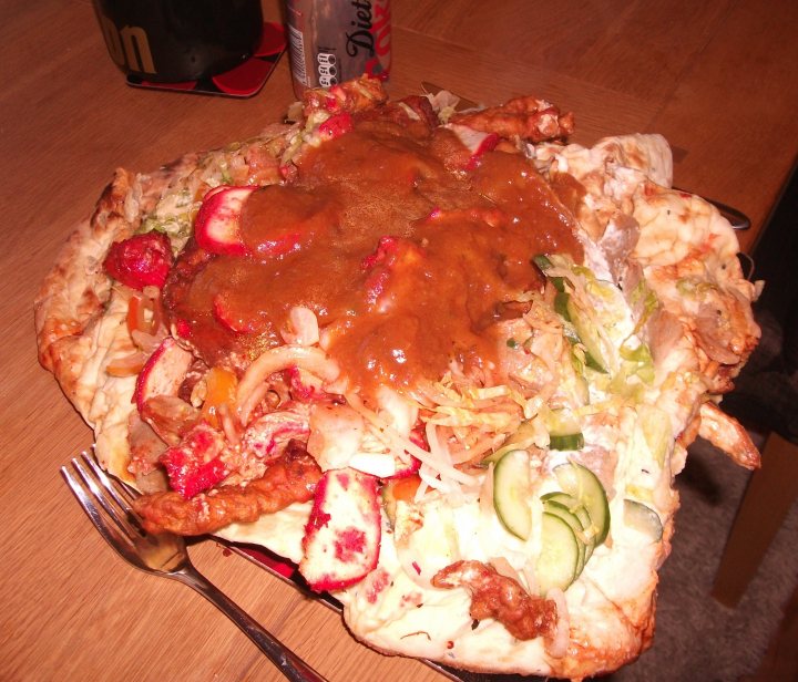 A pizza sitting on top of a white plate - Pistonheads