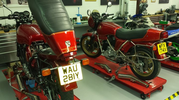 A red motorcycle is parked in a garage - Pistonheads
