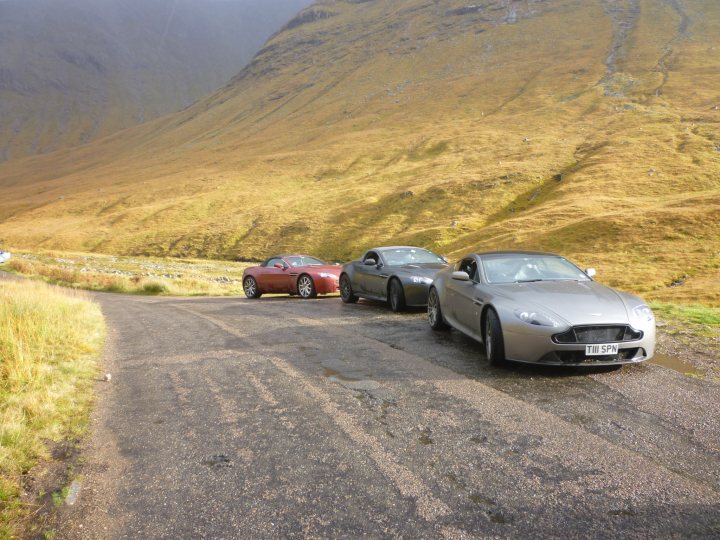 A car driving down a road next to a herd of sheep - Pistonheads
