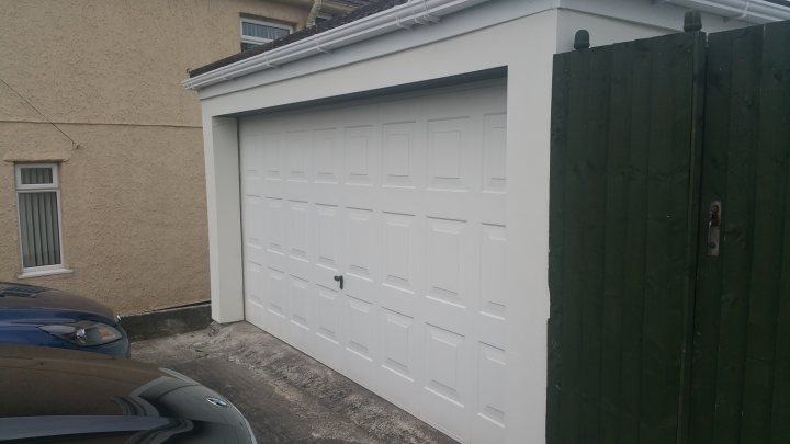 A white door is open to the side of a house - Pistonheads