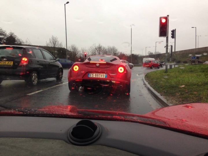 A red car is driving down the street - Pistonheads