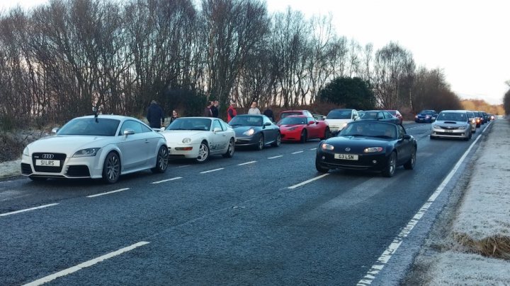 A group of cars are driving down a street - Pistonheads