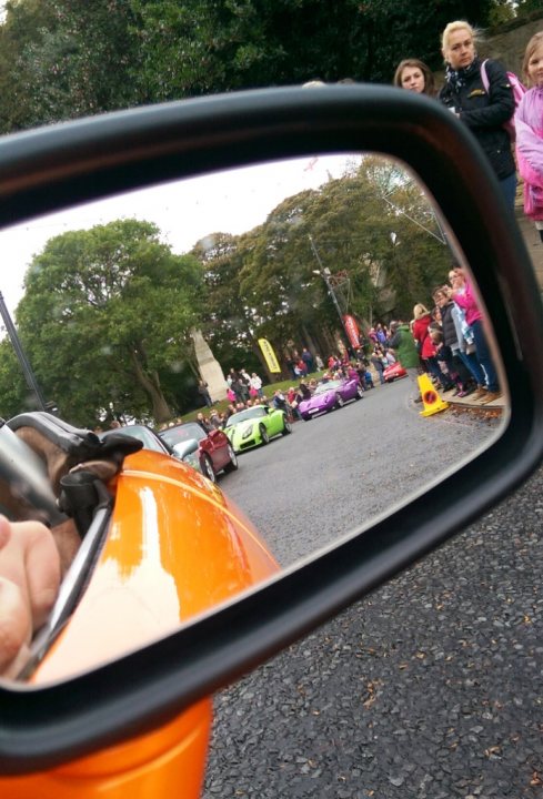 A man taking a picture of himself in a rear view mirror