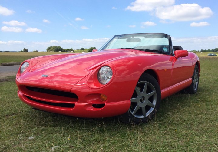 A red and black car is parked in a field - Pistonheads