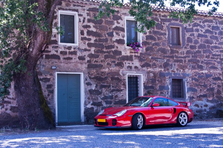 A red car parked in front of a red brick building - Pistonheads