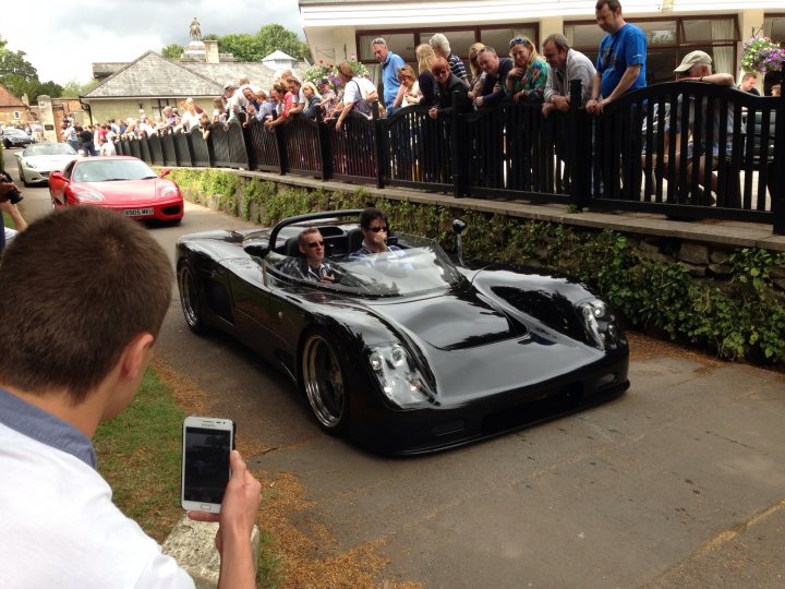A man sitting on a car with a cell phone - Pistonheads