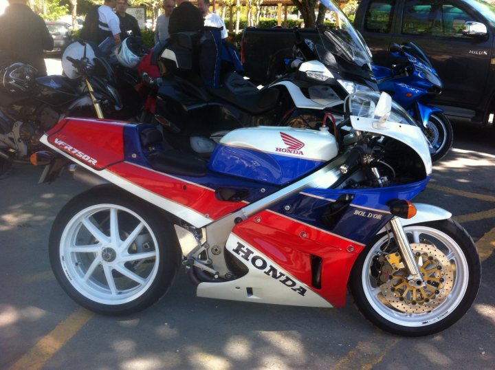 A red motorcycle parked in a parking lot - Pistonheads
