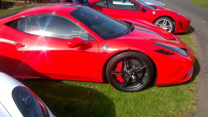 A red and black motorcycle is parked in a field - Pistonheads
