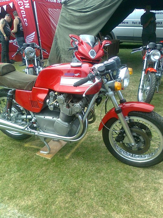 A motorcycle is parked in a grassy field - Pistonheads
