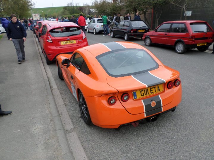 A red car is parked on the side of the street - Pistonheads