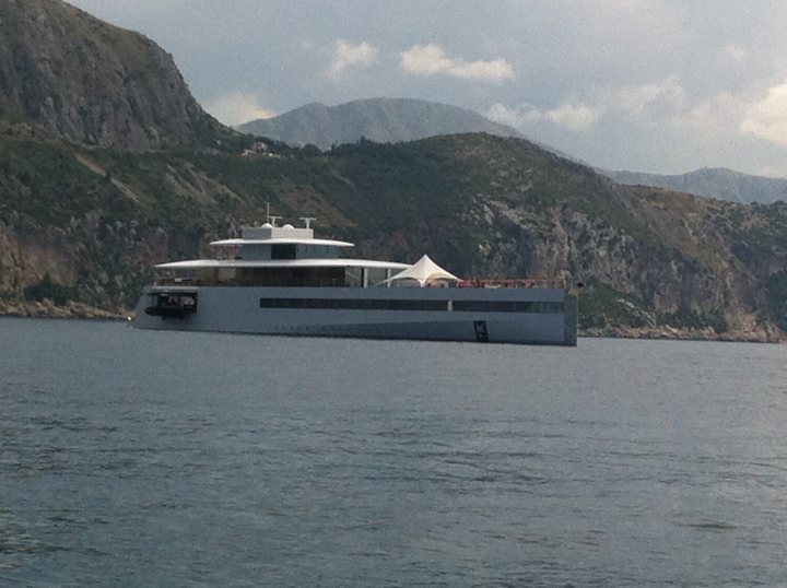 A boat is traveling on the water near a mountain - Pistonheads