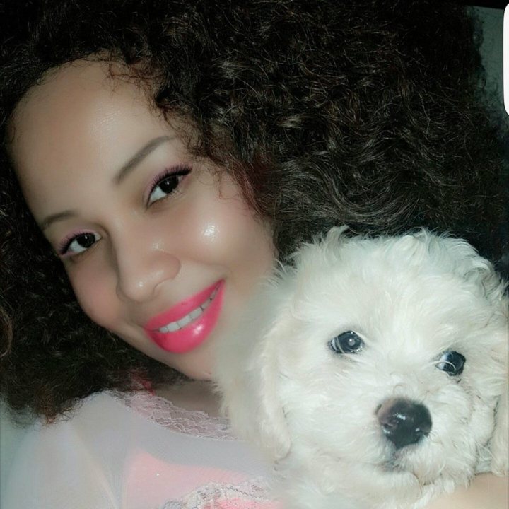 A woman holding a white dog in her arms