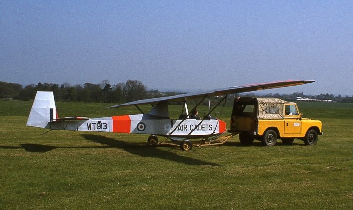 A red and white plane sitting on top of a field - Pistonheads