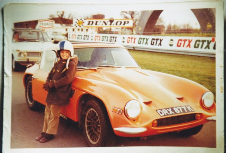 A woman standing next to a red car - Pistonheads