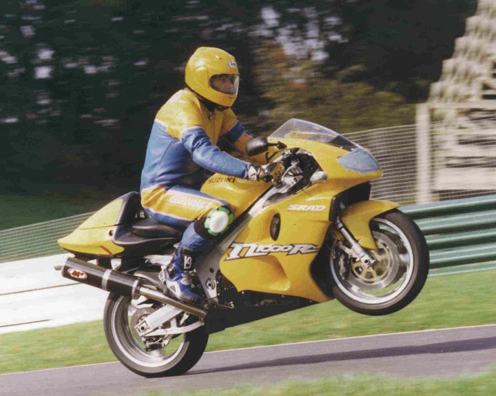 A man riding a motorcycle down a street - Pistonheads