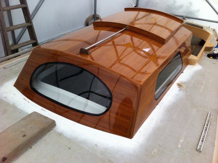 A wooden bench sitting in front of a window - Pistonheads