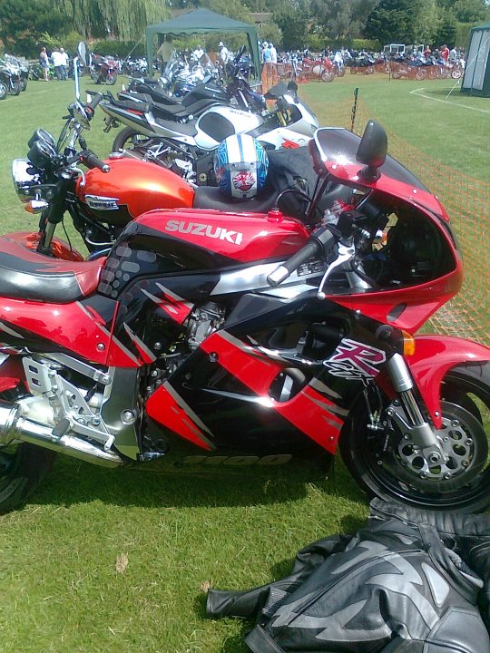 A red motorcycle is parked in a field - Pistonheads