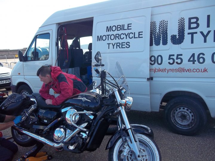 A man is standing next to a parked motorcycle - Pistonheads