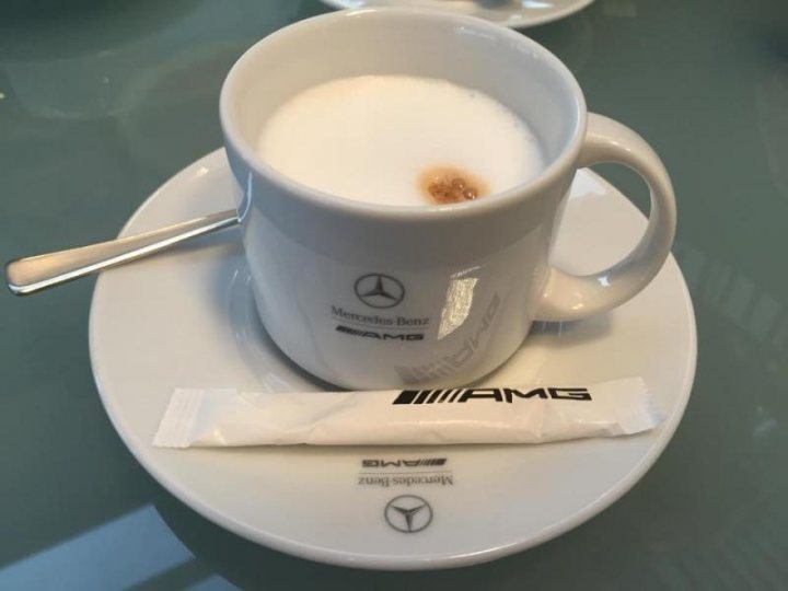 A cup of coffee sitting next to a computer keyboard - Pistonheads