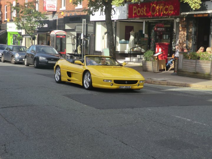 A yellow taxi cab driving down a street - Pistonheads