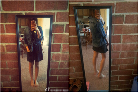 The image is a composite of two photos placed side by side within a single frame, displaying the reflection of a person in a mirror within a room with a brick wall and wooden furniture. In the first photo on the left, the individual is wearing a sleeveless dark dress, holding a smartphone with bare feet, and appears to be standing up. In the second photo on the right, the person is wearing jeans and a light shirt and is shown taking a selfie with the same smartphone. The room setting and the person's attire suggest a casual or informal environment.