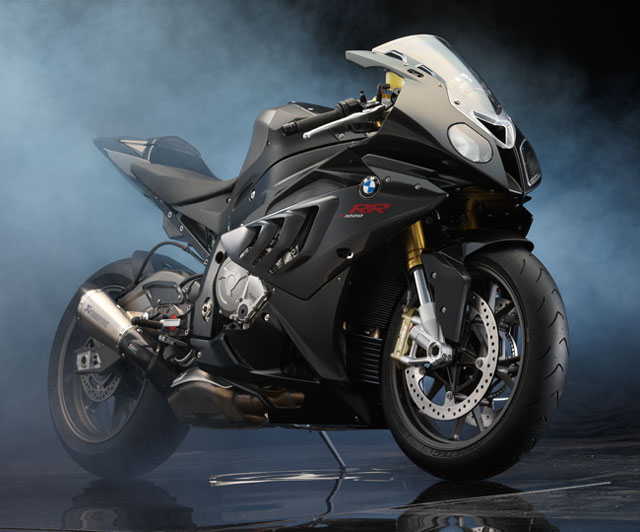 Srr Pistonheads News - The image shows a powerful-looking BMW motorcycle, possibly a sport or touring model, parked against a dark background that produces an interesting visual contrast. It features a streamlined, aerodynamic design suggesting speed and performance. The motorcycle has a sleek, color-coordinated appearance with prominent branding. The rear wheel angles slightly towards the viewer, adding to the dynamic sense of the image.