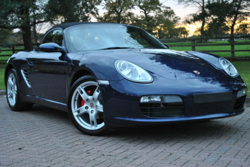 Boxster 987 2.7 17" or 18" alloys for best ride & handling.. - Page 1 - Boxster/Cayman - PistonHeads - The image showcases a sleek, blue Porsche convertible parked on a cobblestone driveway. The car's sleek body and polished appearance glisten under the sunlight, highlighting its design and features. The setting appears serene with a grassy area in the background, suggesting a peaceful suburban or rural location. The car's targa top is in place, but the open side window allows a glimpse of the interior. The Porsche convertible exudes a sense of luxury and sportiness, indicative of its performance and quality.