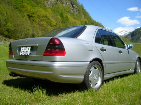 Ticino - Page 1 - Switzerland - PistonHeads - The image showcases a grey sedan parked on a grassy area. The car, with its compact and elegant design, is the focal point of the image. It's situated on the right side of a road, which is slightly blurred, indicating the car is stationary. The car appears to be well-maintained, with a clean and polished finish. The background of the image reveals a serene, grassy landscape, punctuated by the presence of mountains in the distance. The overall scene suggests a peaceful and tranquil environment, away from the hustle and bustle of urban life. The colors in the image are predominantly green (from the grass) and grey (from the car), creating a harmonious and natural palette.