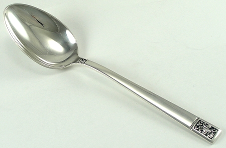 New Teaspoon Advice Please - Page 5 - The Lounge - PistonHeads - The image presents a shiny, silver metal coin purse. It appears to be sitting on a white, smooth surface. The purse is in the shape of a spoon, but it includes a handle that extends from the back end for a secure grip. The handle itself is embellished with a decorative floral pattern at the end. The purse appears to be empty as it is open and no coins are visible. The background is neutral, allowing the purse to stand out as the primary subject of the image.