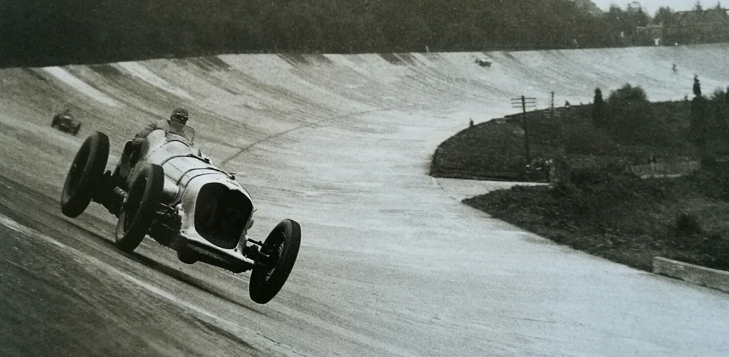 Pembleton mkII - Tin Tub - Page 2 - Readers' Cars - PistonHeads - The image features a vintage car race taking place on a steep incline. The car, appearing to be an old model with a prominent hood, is positioned on an open road, close to the side of the road, as it descends the hill. In the distance, there are a few spectators watching the race. The background is hazy and shows a forested area, creating an atmosphere of depth and age. The event appears to be taking place in an old-fashioned outdoor setting, suggesting it might be an early to mid-20th-century photograph.