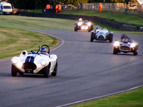 A motorcycle is parked on the side of the road - Pistonheads - This image captures an exhilarating scene on a twisting race track. Five racing cars, led by a white and blue one, are skilfully navigating the turns. The track itself is set among lush green surroundings, and in the background, there's a stretch of road lined with verdant trees. A few spectators can be seen in the distance, their focus intently on the speeding cars, adding to the thrilling atmosphere. The image encapsulates the spirit of competitive racing and the excitement it brings to an audience.