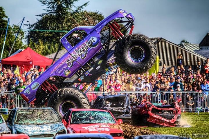 A truck is parked in a parking lot - Pistonheads - The image captures a thrilling scene of monster truck racing in an enclosed arena. Two vehicles are in action, one is flipping over another vehicle which is already damaged with a visible dent. Spectators, dressed in various colors of jackets, fill the background, their faces a mix of excitement and anxious anticipation. The trucks themselves are large and commanding, their colors contrasting with the turquoise arena and the lush green field that surrounds the track. A few trees are scattered around the venue, adding a touch of nature to the otherwise urban setting.