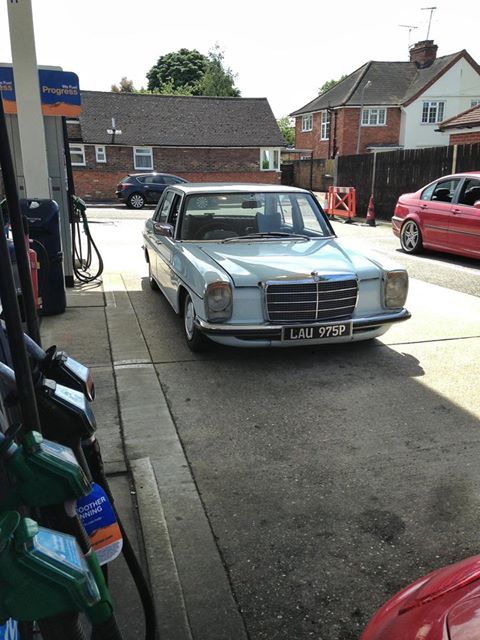 Recommendations for garages that specialise in old cars? - Page 1 - Thames Valley & Surrey - PistonHeads - In the image, an old Mercedes-Benz taxi is parked in a lot adjacent to a gas station. The car appears to be stationary, possibly indicating that it is not currently in service. The setting suggests a typical day at a gas station, with other cars visible in the background. The gas station itself seems to be a busy one, with multiple pumps and a storefront in the background. The weather seems to be favorable, with plenty of daylight illuminating the scene.