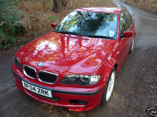 The Best //M/Barge/General Rant/Look at This/O/T Thread... - Page 393 - General Gassing - PistonHeads - The image captures a vibrant red BMW parked on the side of a dirt road, surrounded by a lush, wooded area under a tree canopy. The vehicle, bearing a UK license plate, exudes an aura of luxury and adventure with its gleaming exterior and shiny rims. The BMW's sleek design and polished finish stand out against the natural backdrop, contrasting the rugged charm of the forest with the refined elegance of the car. The fact that the doors are open suggests someone might be preparing for a journey or perhaps taking a break to enjoy the tranquil surroundings. The entire scene evokes a sense of adventure, the thrill of the open road, and the journey that lies ahead.