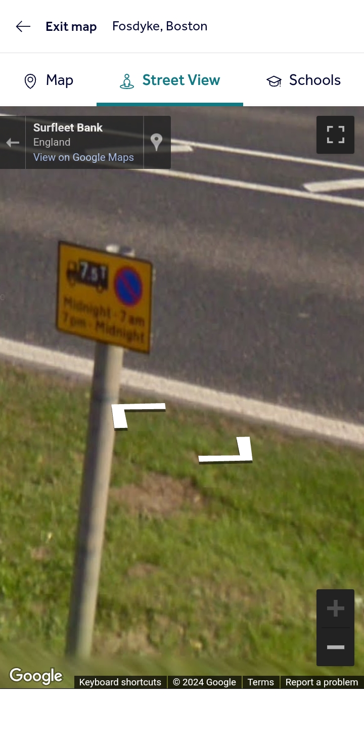 Pistonheads - The image shows a smartphone with a screenshot of a map application. The map is focused on an area where there's a street sign visible, though the text on the sign isn't legible in this snapshot. The user interface elements suggest that the phone is navigating or displaying directions related to this location. At the bottom of the image, we can see what appears to be a street view or live camera feed of the same area, showing the surrounding environment and a sign post with a blue marker on top of it.