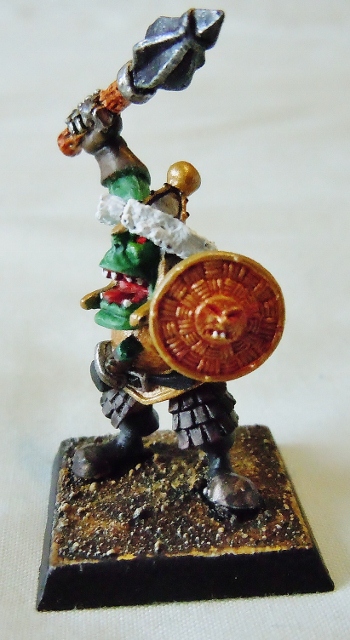 A statue of a bird sitting on top of a table - Pistonheads - The image presents a dynamic scene of a small, barbarian-like figurine, set on a light wood base. The figurine is wielding a large, gleaming sword that extends upward, as well as a smaller axe, perhaps representing a unique style of combat. The warrior's green skin and red hat give the impression of a dark or evil character, evoking a sense of tension and conflict. The detailed craftsmanship and the plush base underneath the figurine add a touch of realism to the scene. The image beautifully captures the captivating details of this tiny yet intense piece of artwork.