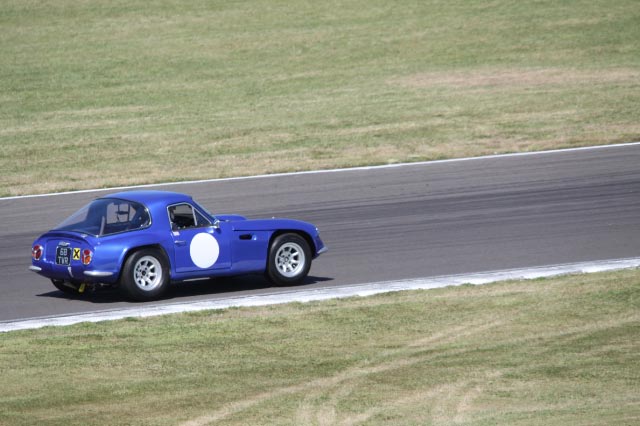 Early TVR Pictures - Page 24 - Classics - PistonHeads - The image showcases a dramatic race scene where a blue sports car is in action. The car is speeding down a race track, its body gleaming under the track lights. The background, though blurred due to the high-speed photography technique, provides a sense of the race environment with its markings, indicating a venue for professional car racing. The copyright symbol followed by the year 2015 is prominently displayed, possibly indicating the image's origin or the year of the race's broadcast.