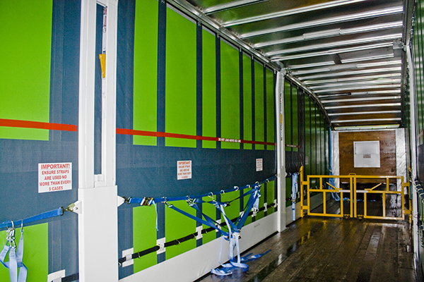 So, what exactly do you do then? - Page 1 - Commercial Break - PistonHeads - The image displays the inside of a shipping unit or container. The walls are painted blue, alternating with green, and a white dividing wall runs vertically down the center. On this dividing wall, various warning signs are visible, indicating the presence of hazards or the importance of safety protocols within this space.

White poles with attached chains can be seen, likely used for securing cargo to prevent movement during transit. The floor of the container is laid with yellow tape, possibly for safety reasons. The overall brightness of the container suggests it is either lit naturally or with artificial lighting.

At the entrance, a gated portal is open, allowing us to view the interior of the container. The gate seems to be a temporary entry solution to facilitate loading or unloading of goods.

Safety railings and a handrail can be seen, providing support to those navigating the space inside the container. This suggests the area within the container can be hazardous or require additional care while moving around.