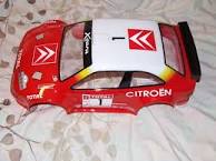 Show us your RC - Page 1 - Scale Models - PistonHeads - The image presents a toy car that appears to be from the "Tics" brand. The car is primarily red with white and black graphics. The most striking feature of the car is a large black letter "X" on its side. In addition to this, there's sponsorship signage that reads "Citroen", indicating a collaboration between the car model (a AC10 TOYOTA) and the Citroen company. The car is shown from the perspective of the front right side and seems to be made of plastic with simulated windows and doors.